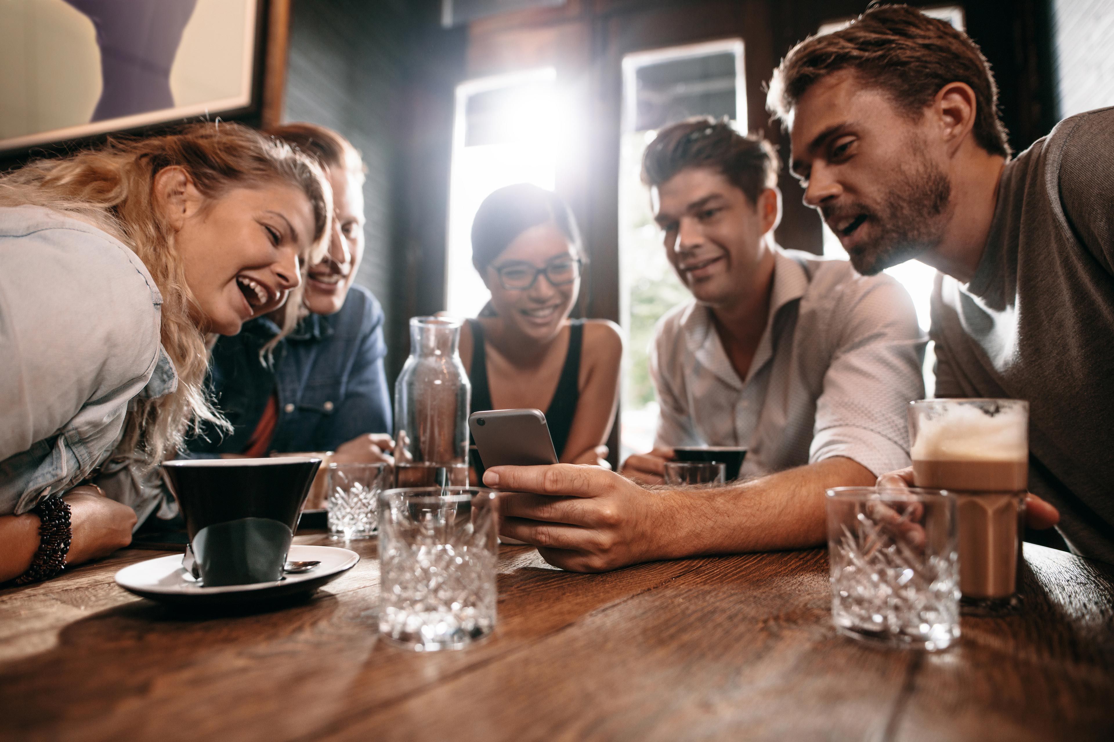 Friends around table with a mobile phone
